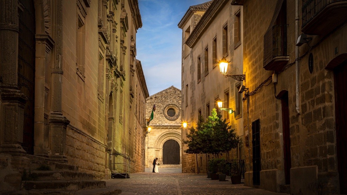 Mariés au loin dans une ruelle de vieille ville illuminée